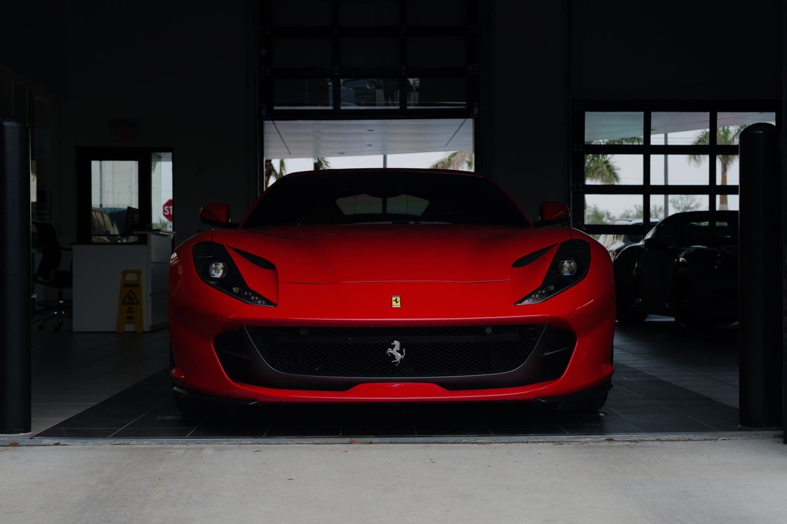 Red sports car on a dark gloss coated floor in a private garage — a premium finish example